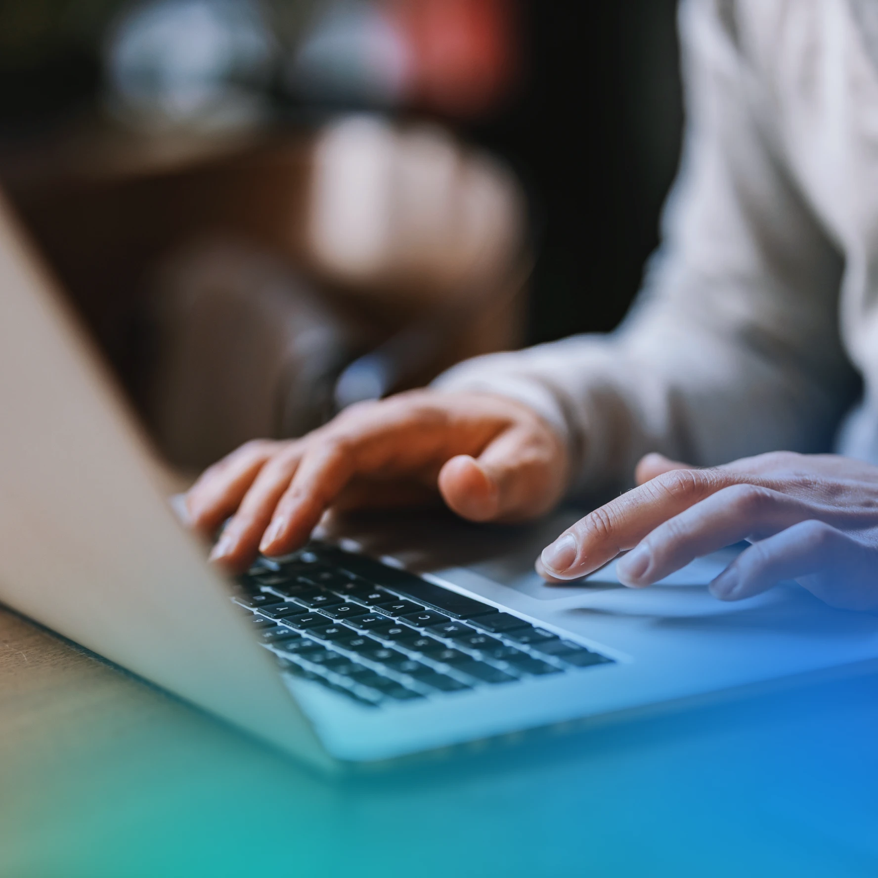 Hands typing and scrolling on a laptop