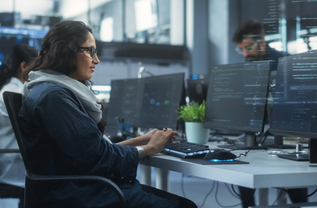 Woman writing code on a computer in a modern office