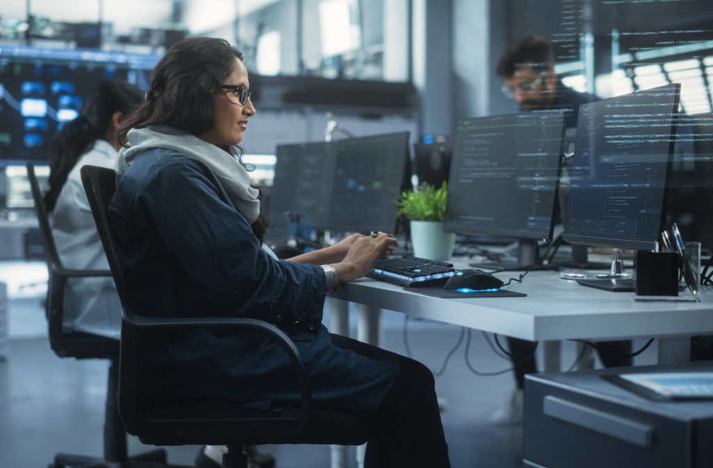 Woman writing code on a computer in a modern office